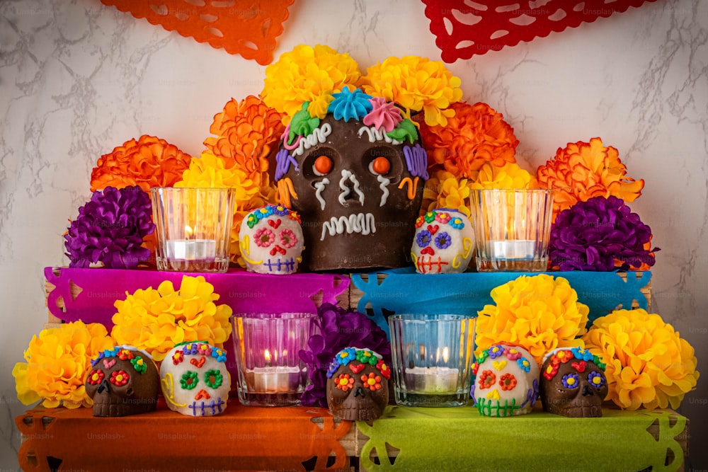 a table topped with a cake covered in sugar skulls