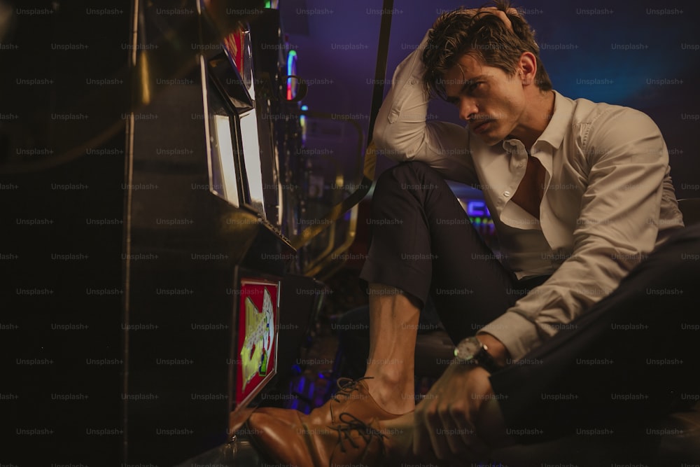 a man in a white shirt and tie tying his shoes