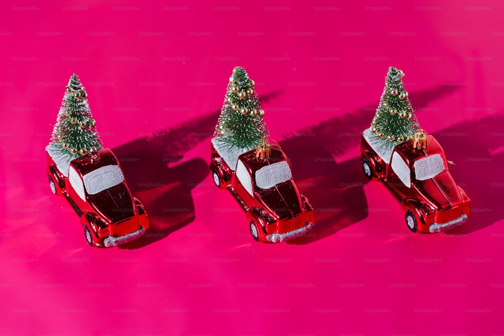 three small cars with a christmas tree on top of them