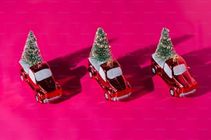 three small cars with a christmas tree on top of them
