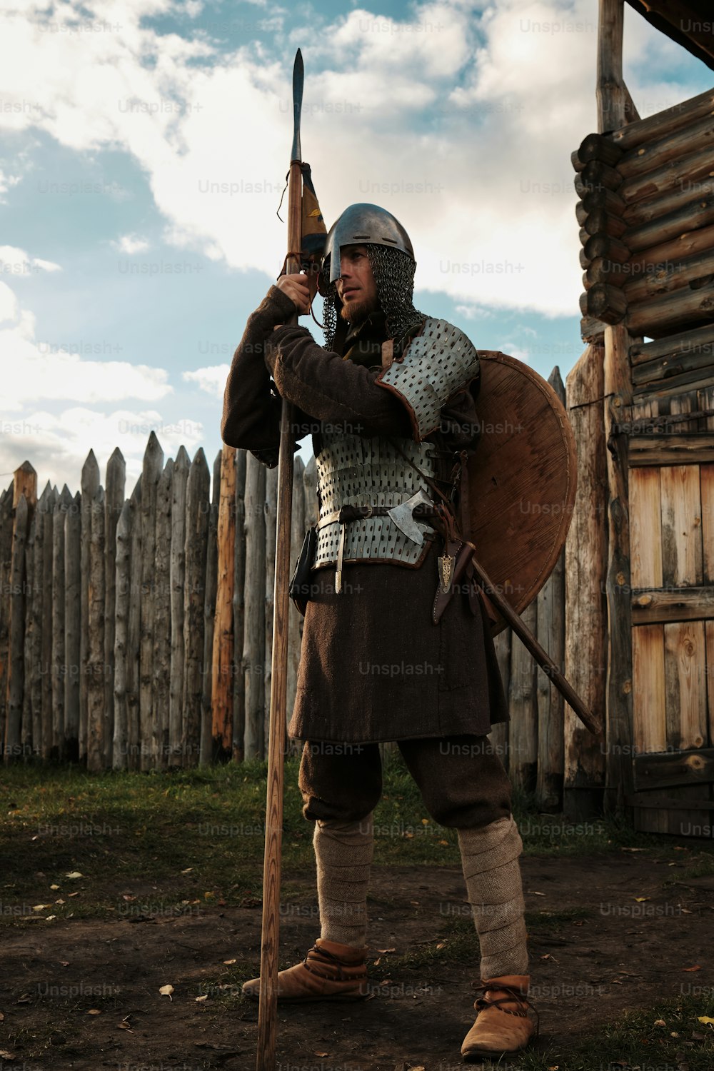 um homem vestido com roupas medievais segurando uma espada e um escudo
