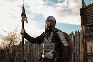 a man in a medieval outfit holding a flag