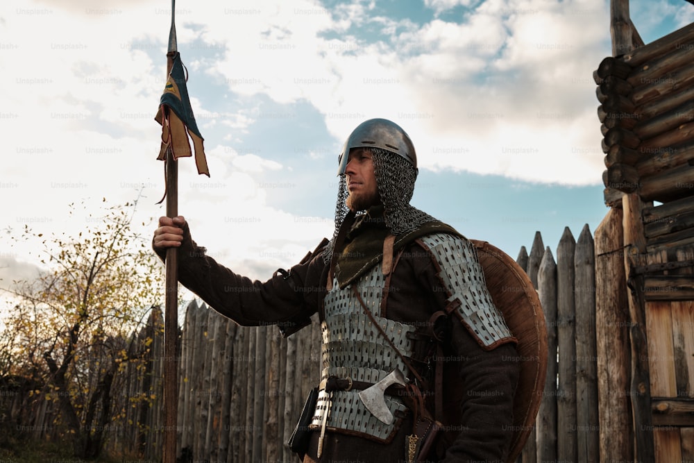 um homem com uma roupa medieval segurando uma bandeira