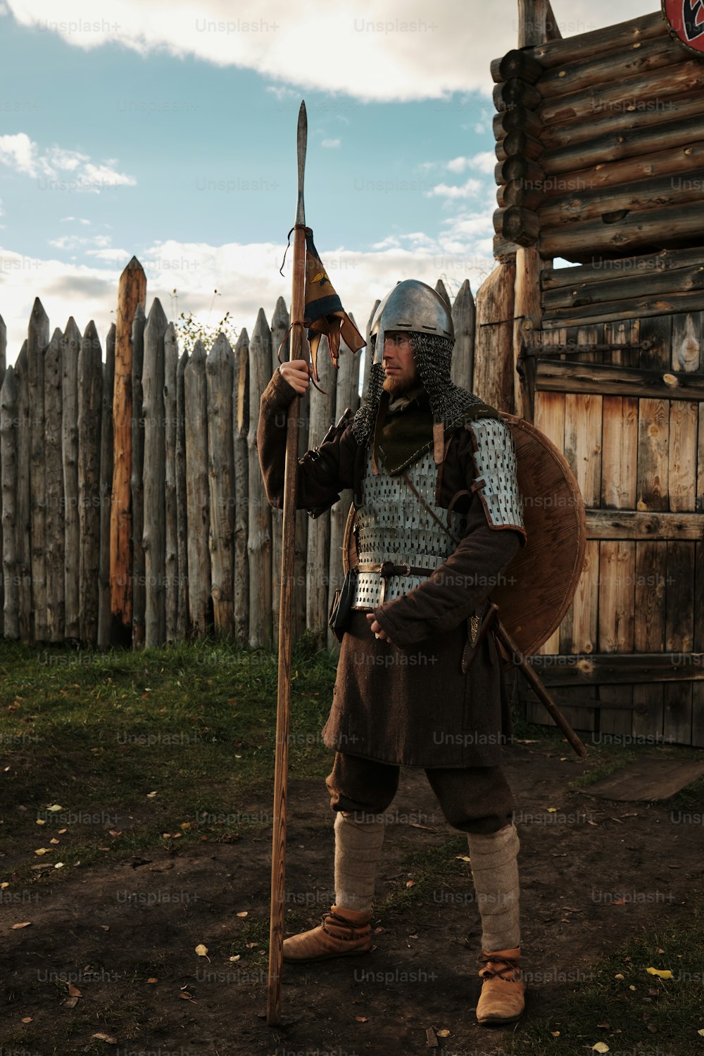 Un hombre vestido con ropas medievales sosteniendo una espada