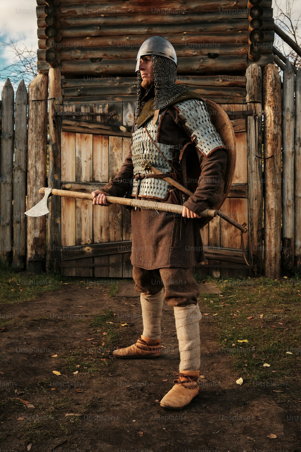um homem vestido com roupas medievais segurando um bastão