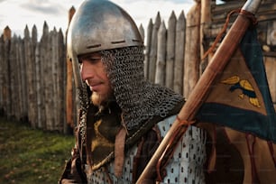 a man dressed in armor holding a flag