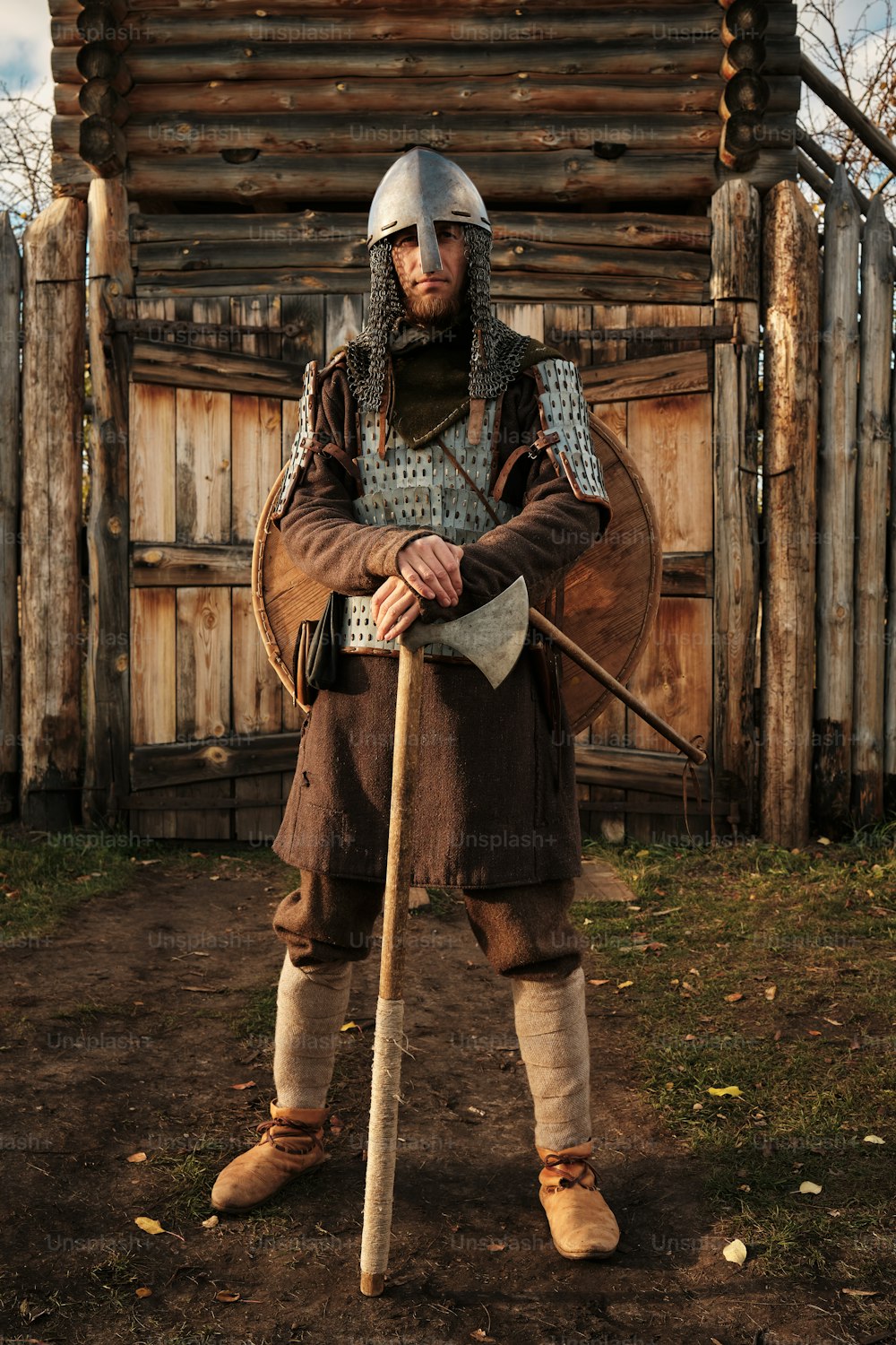 um homem vestido com roupas medievais segurando um bastão de madeira