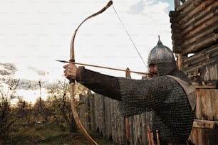 a man dressed in armor holding a bow and arrow