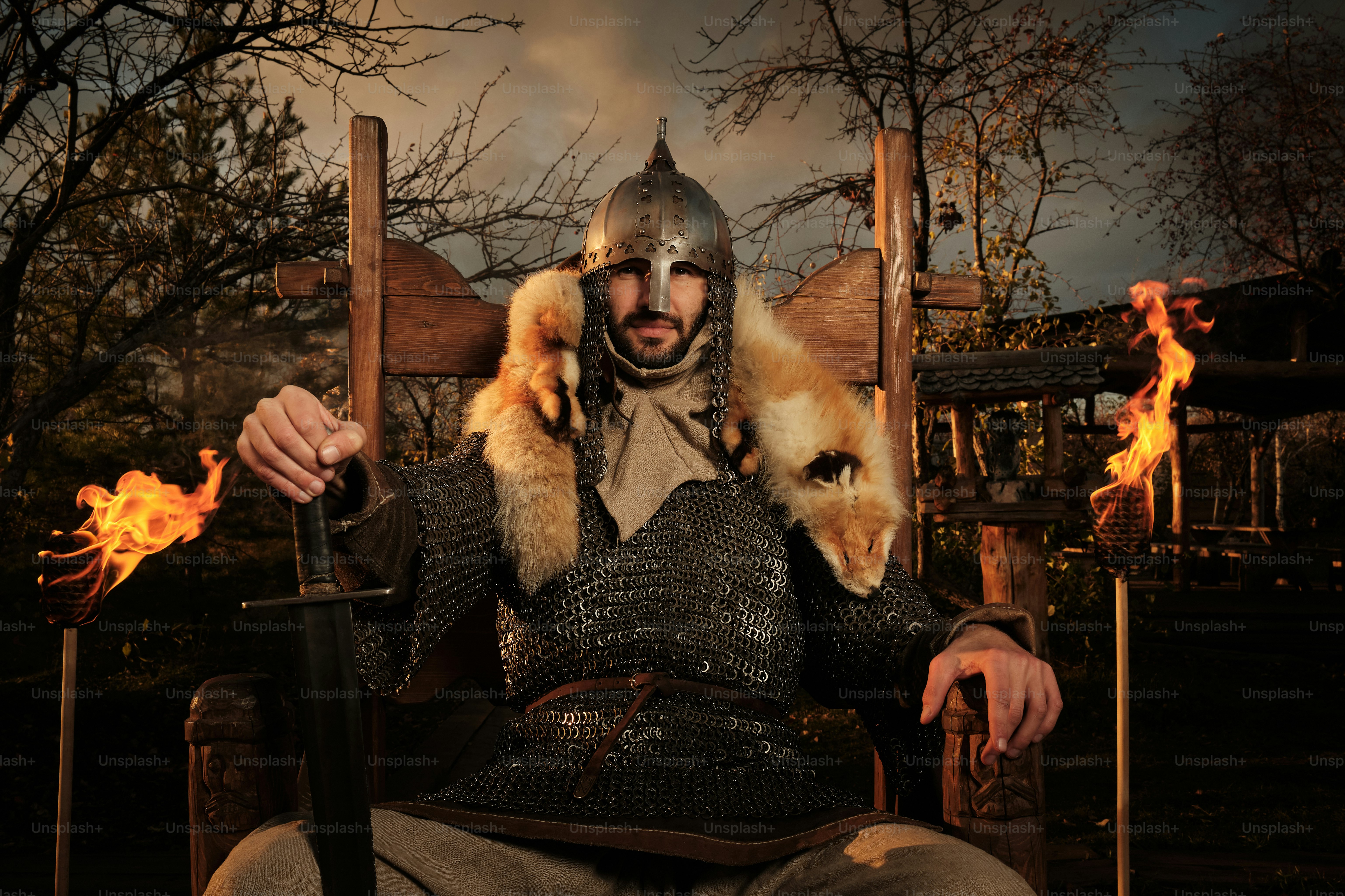 기사 의상을 입은 남자가 의자에 앉아 있다