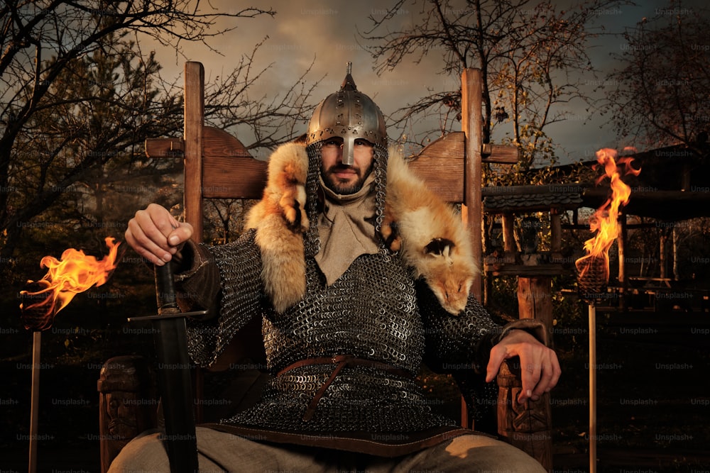 a man in a knight costume sitting in a chair