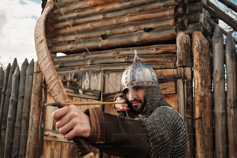 un homme habillé en chevalier tenant un arc et des flèches