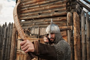 a man dressed as a knight holding a bow and arrow