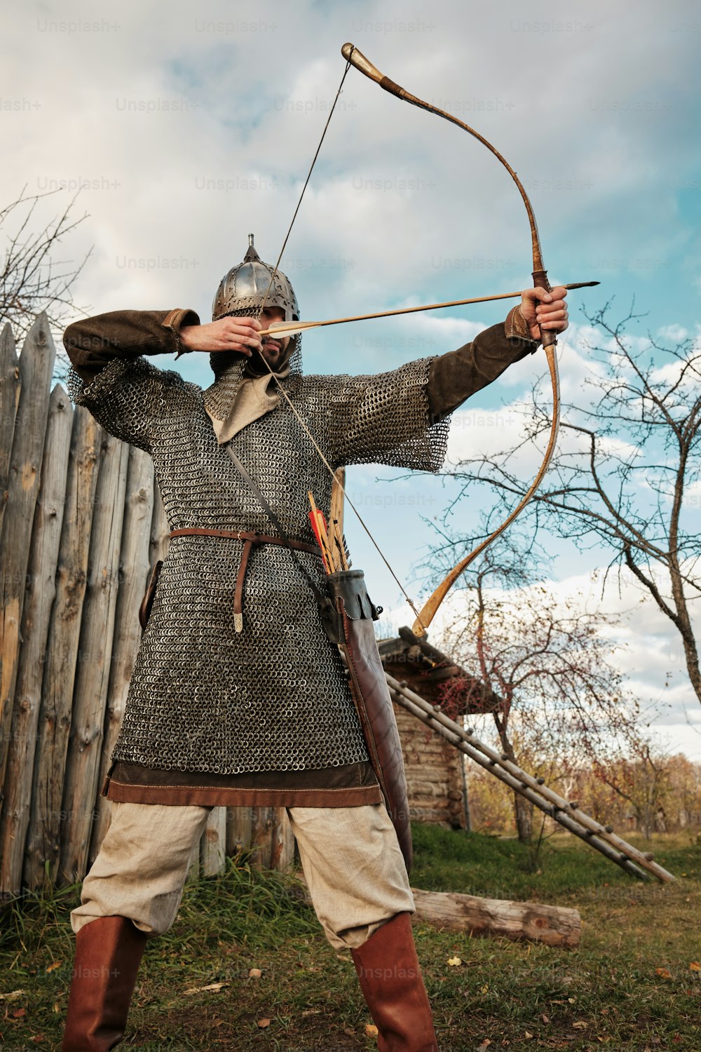 Ein als Ritter verkleideter Mann mit Pfeil und Bogen