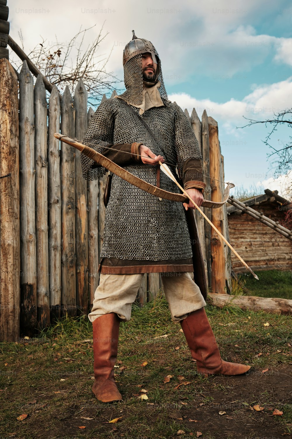 Ein Mann in mittelalterlicher Kleidung mit Pfeil und Bogen in der Hand