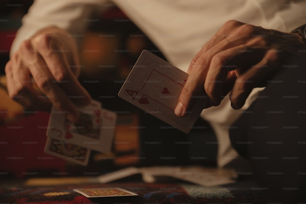 um homem segurando um baralho de cartas nas mãos