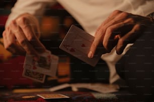 un hombre sosteniendo una baraja de cartas en sus manos