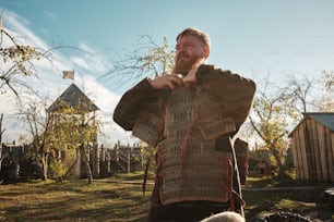 a man standing in a field next to a tree