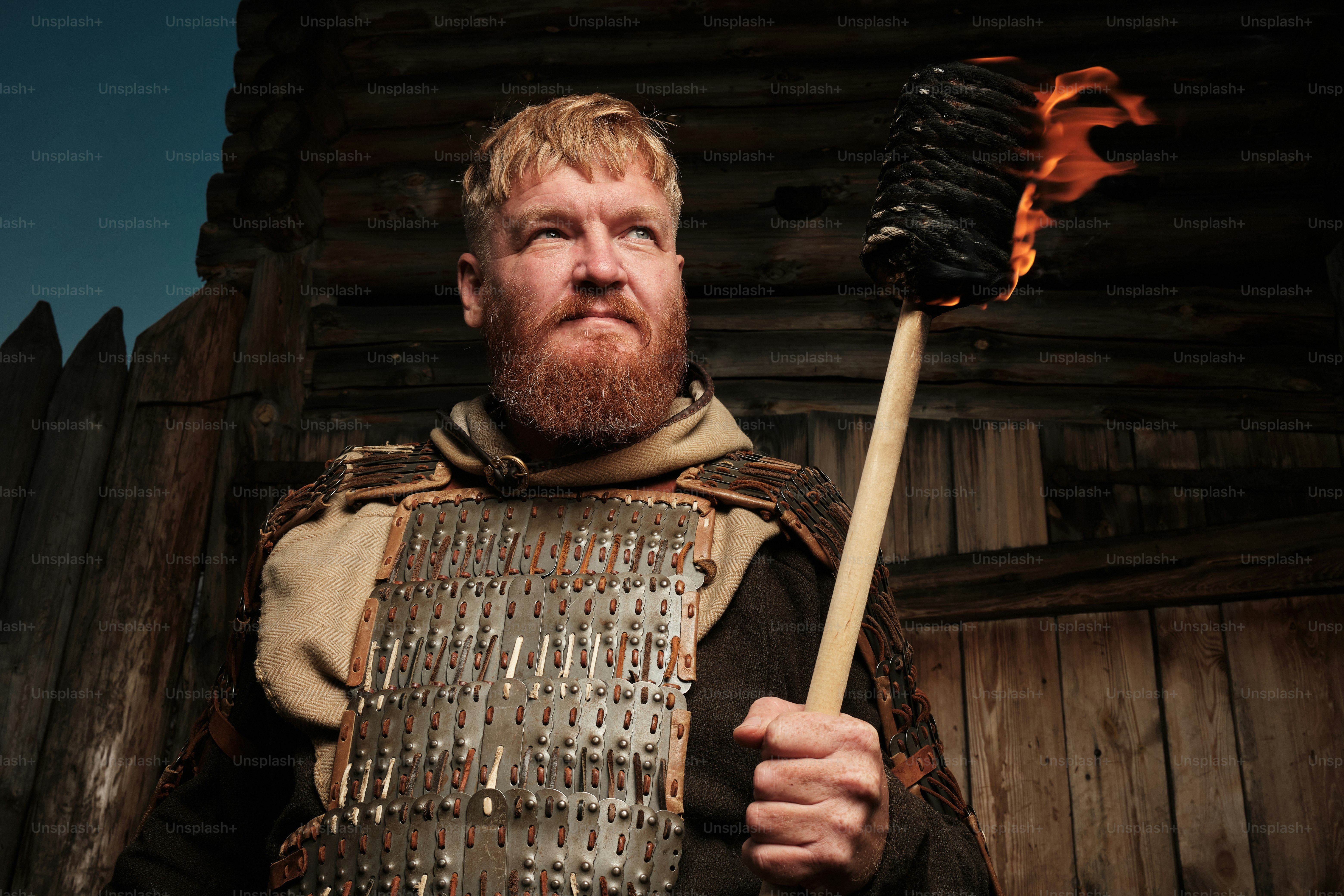 a man dressed in armor holding a fire stick