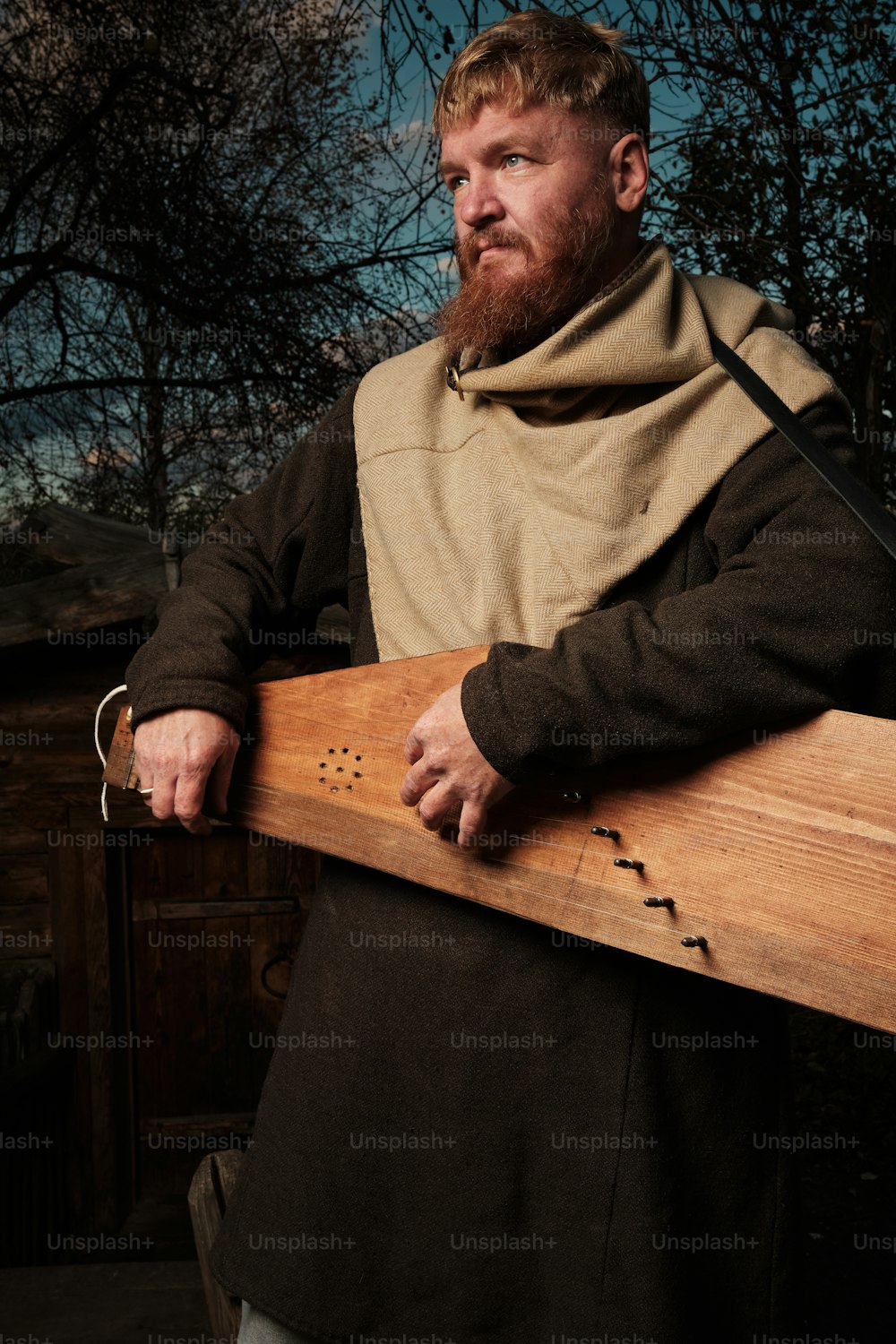 a man with a beard holding a wooden board