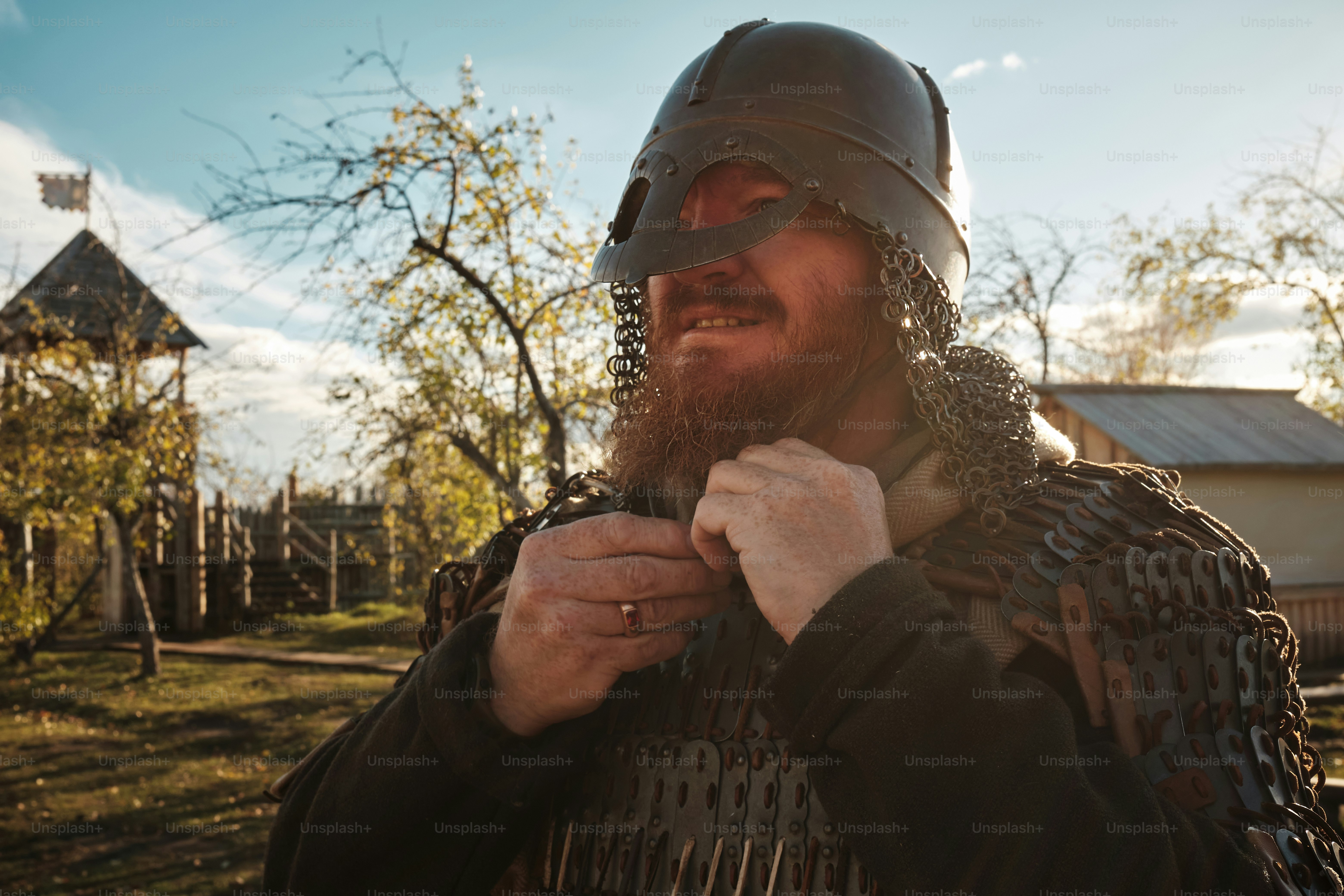 a medieval warrior puts on his armor