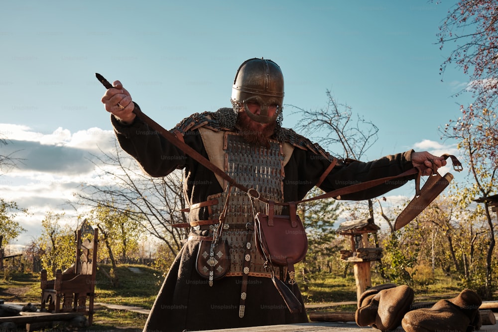 um homem vestido com roupas medievais segurando uma faca