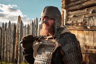 um homem com barba usando capacete e armadura