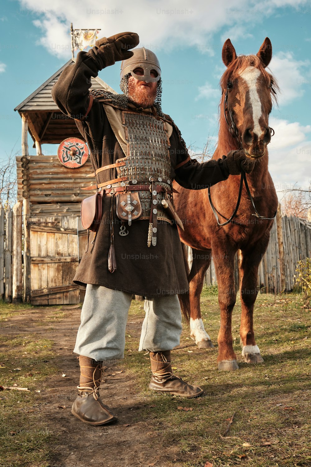 Un hombre de pie junto a un caballo marrón