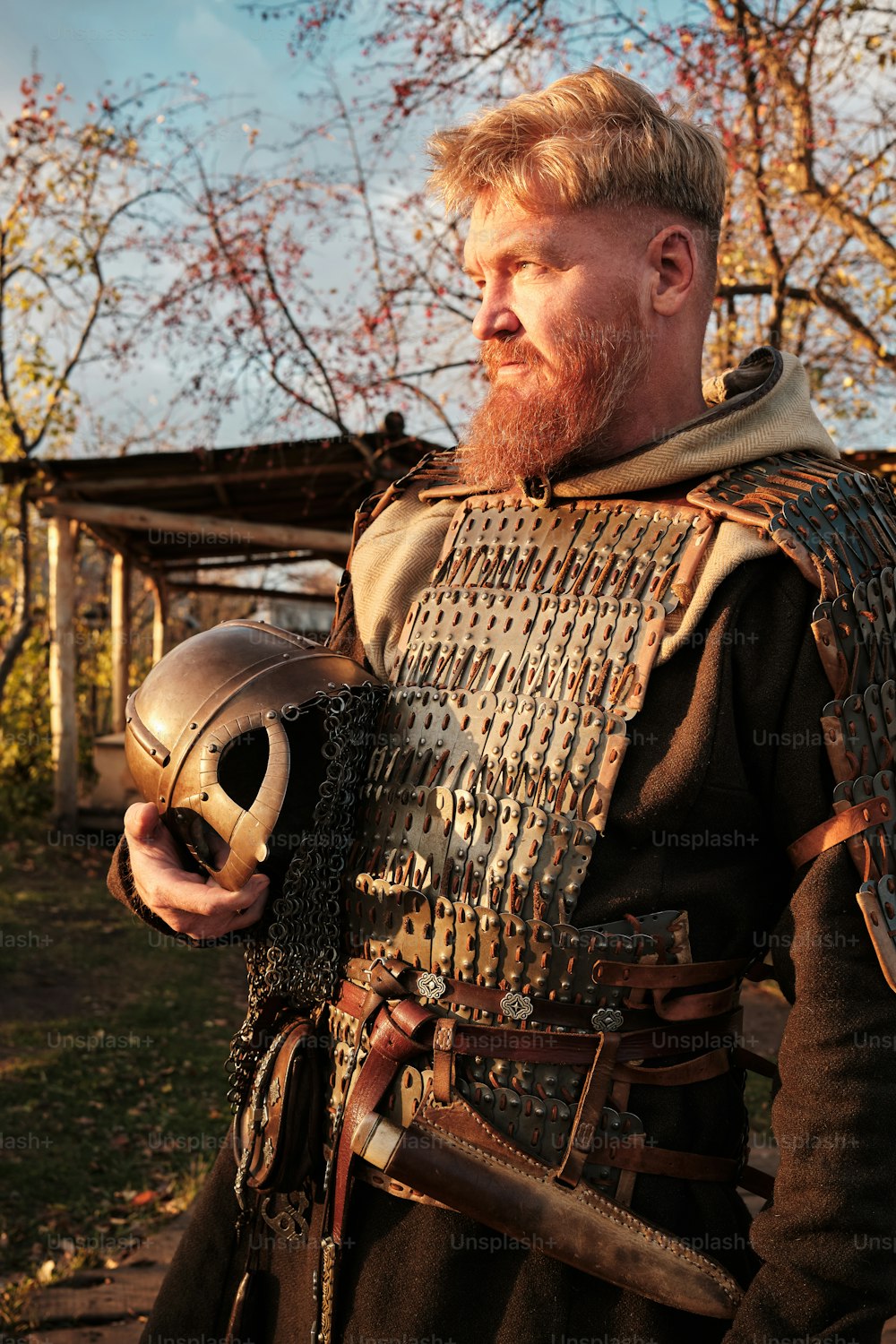 un uomo in costume medievale che tiene in mano un elmo
