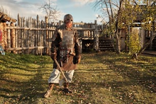 a man dressed in medieval clothing standing in a yard
