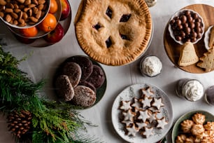 a table topped with pies, cookies and other foods