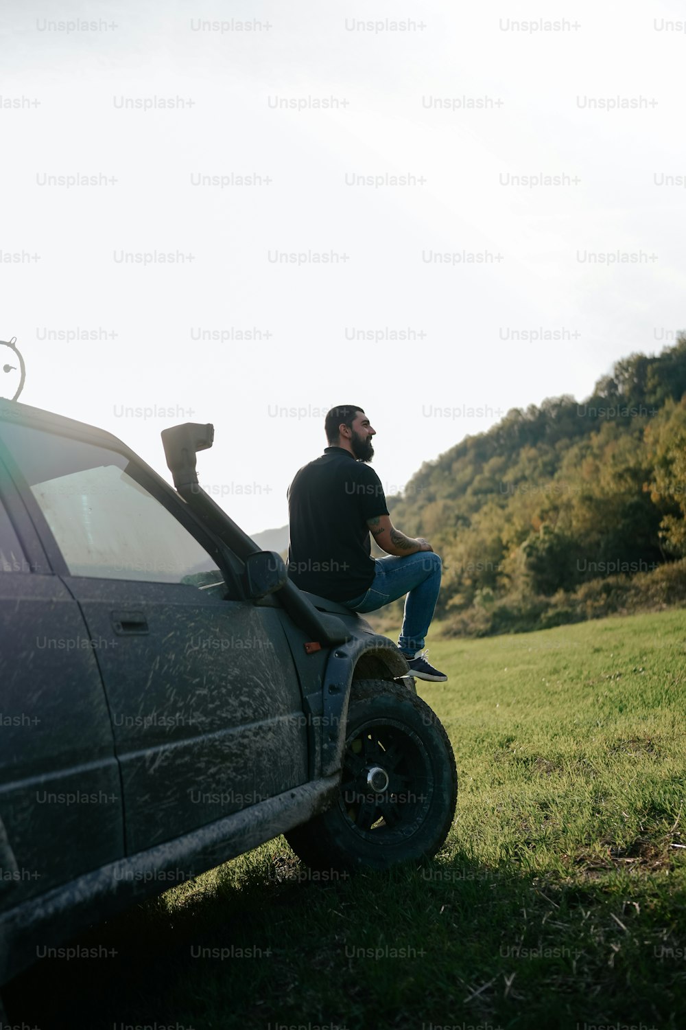 a man sitting on the hood of a car
