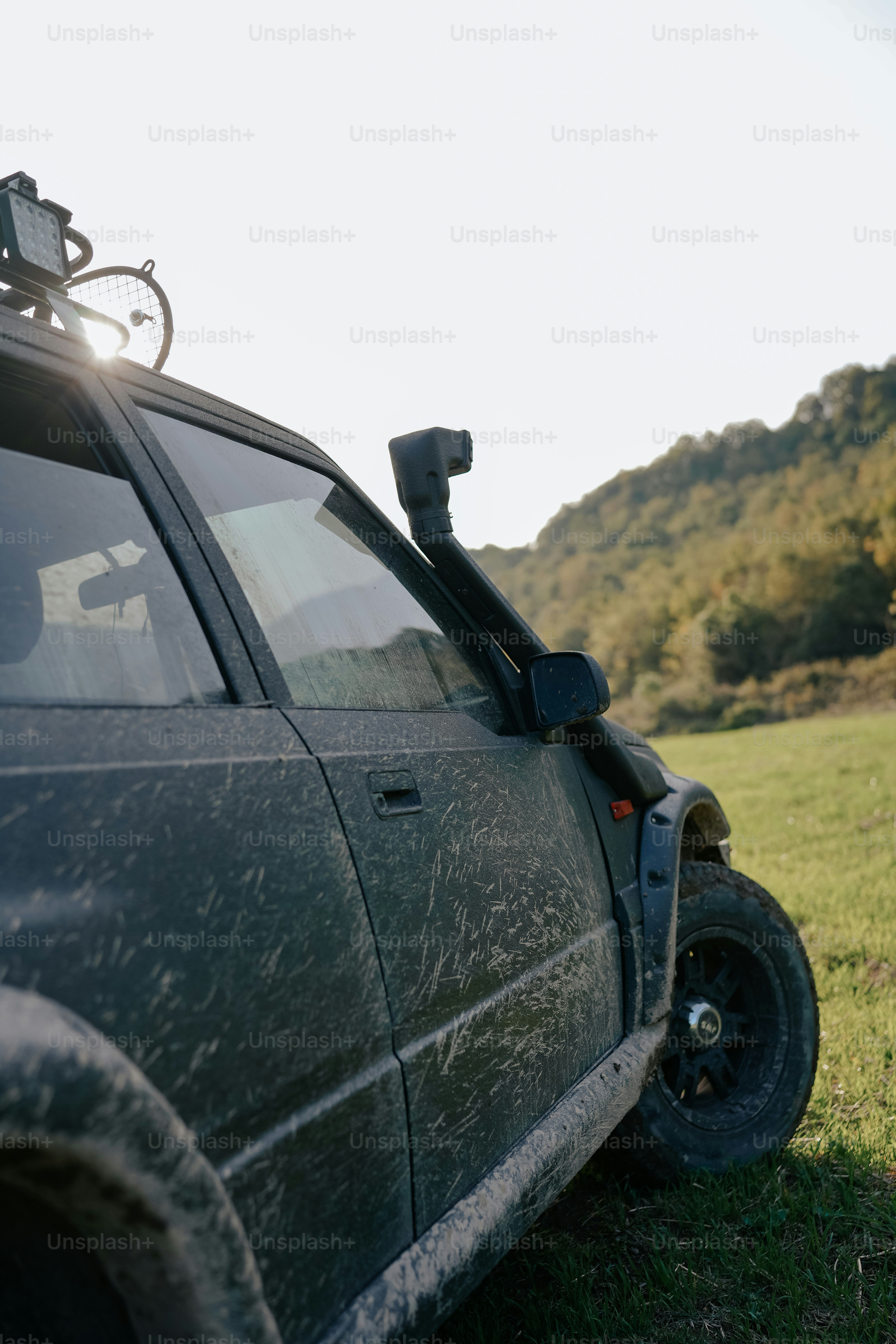 une voiture garée dans un champ avec un vélo sur le toit