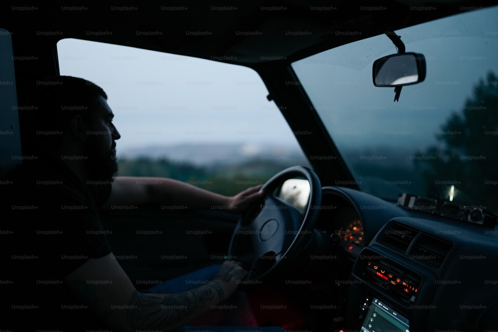 Un hombre conduciendo un coche en la oscuridad