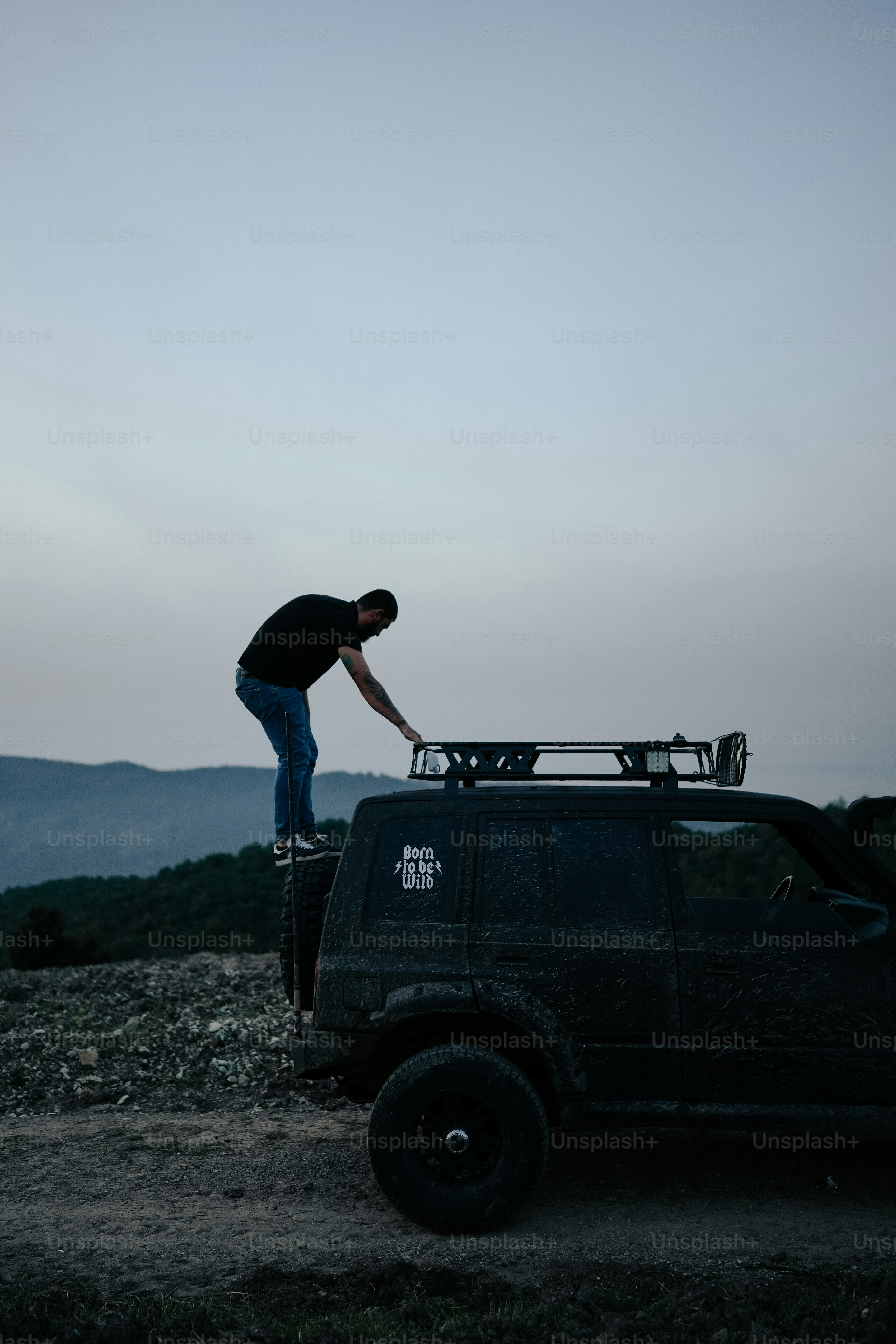 Un homme debout sur le toit d’un camion noir
