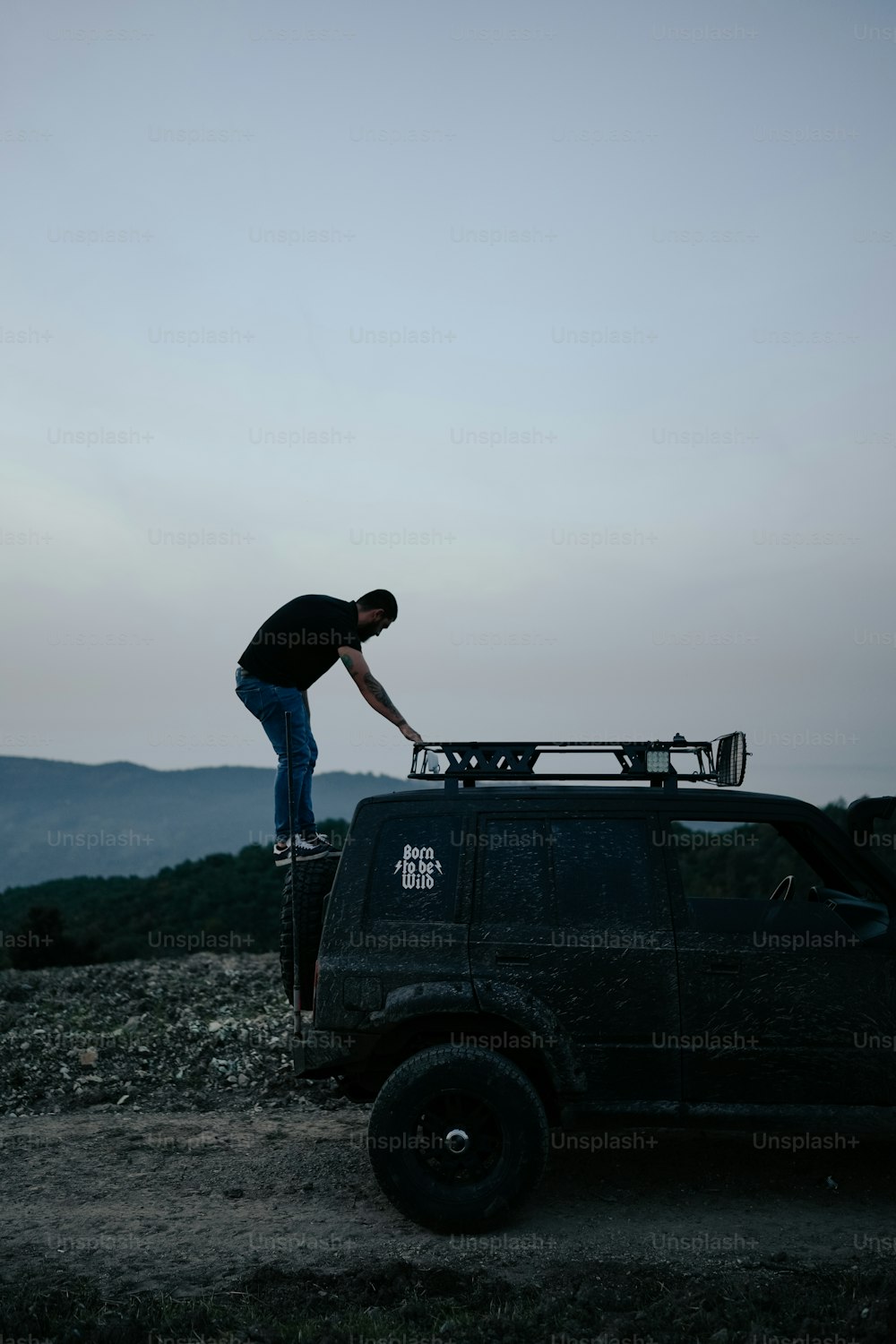 a man standing on top of a black truck