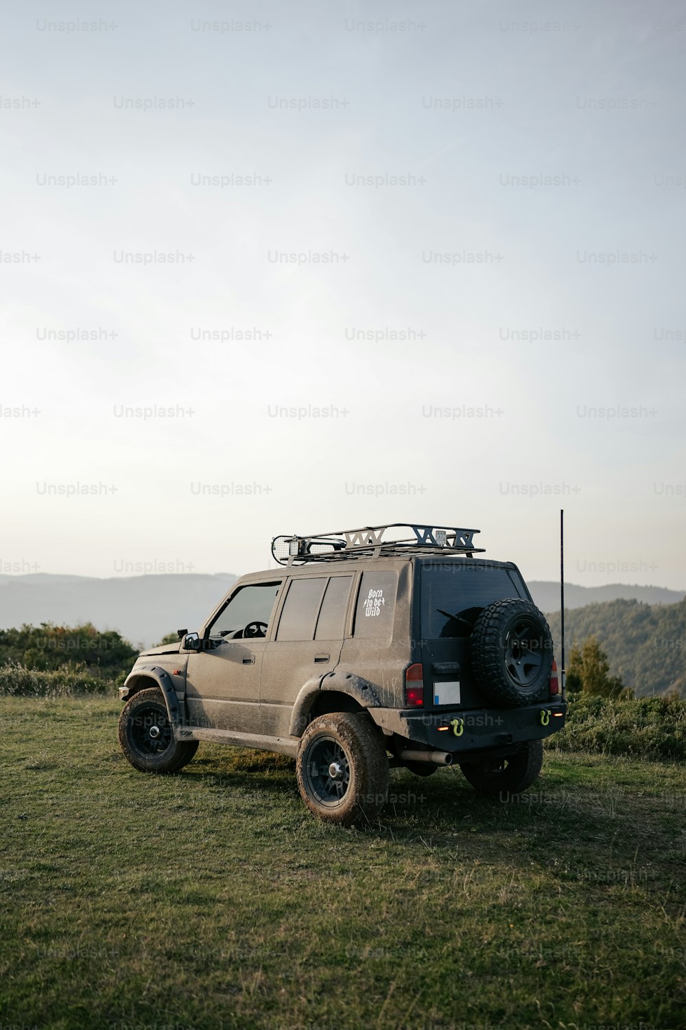 a vehicle parked in a field with mountains in the background