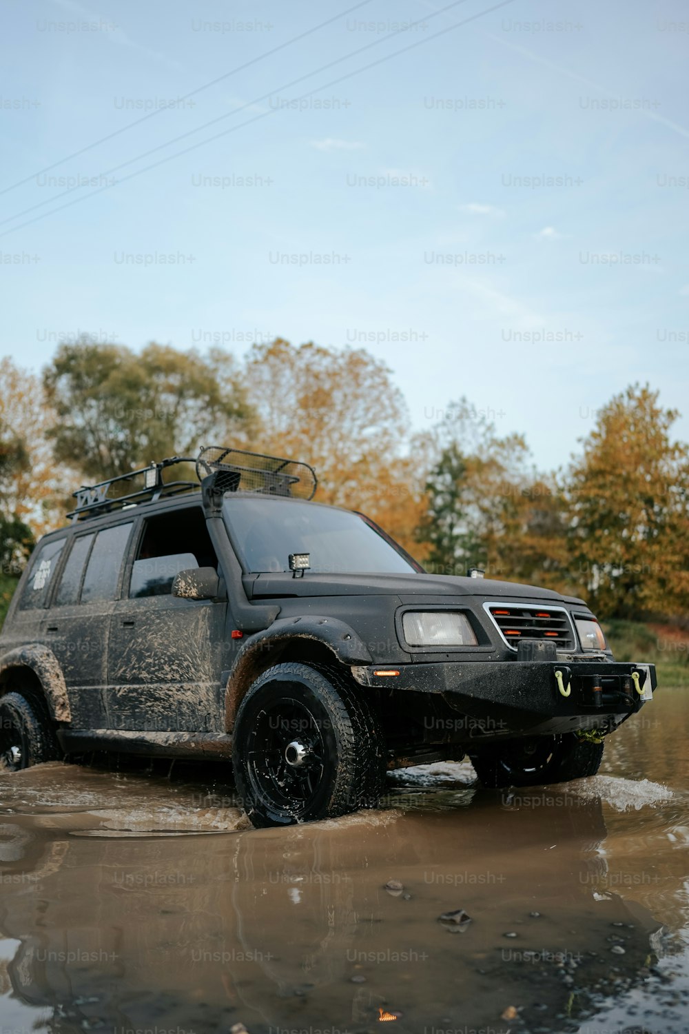 a black suv driving through a puddle of water
