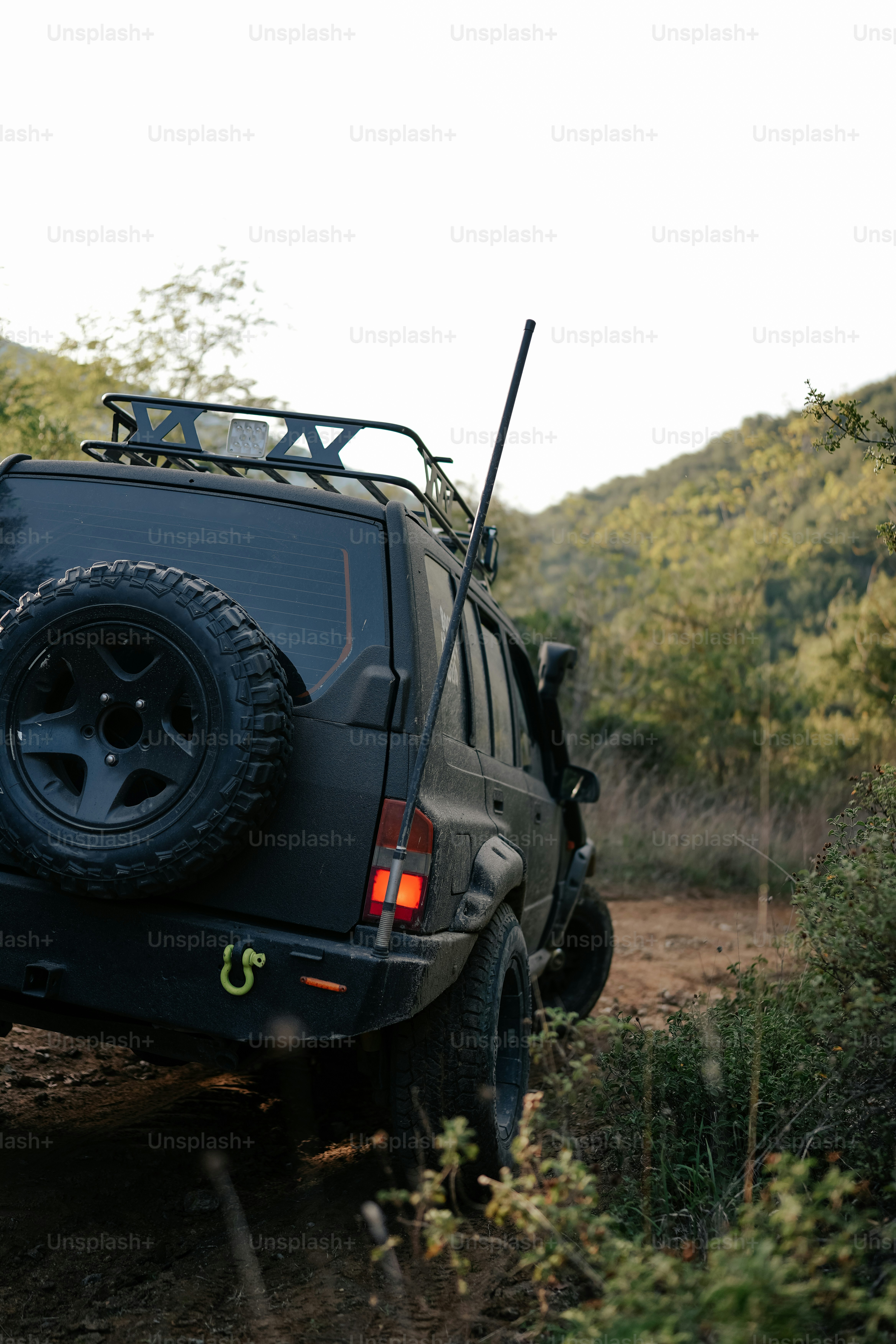 a jeep is parked on the side of a dirt road