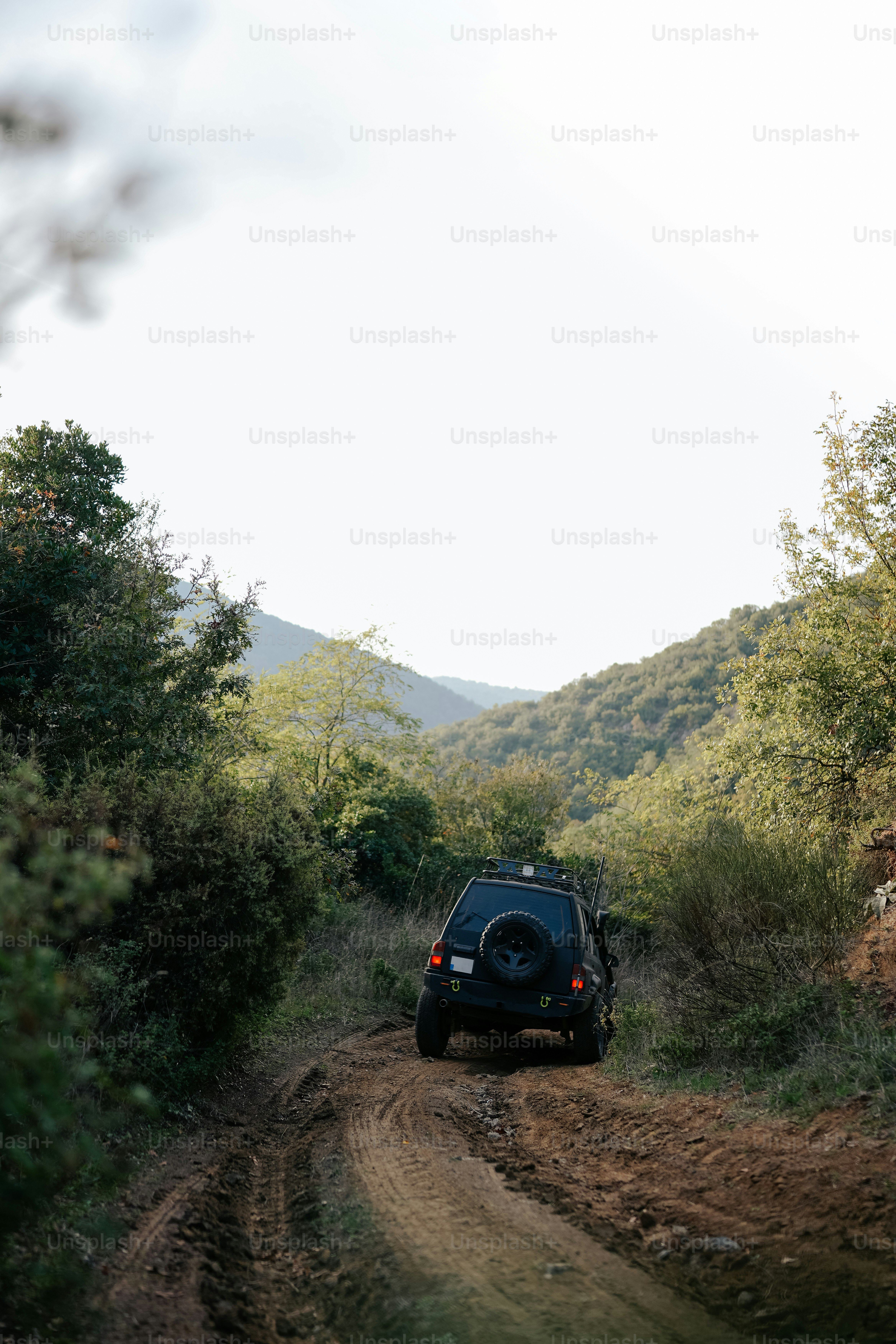 Une voiture roule sur un chemin de terre