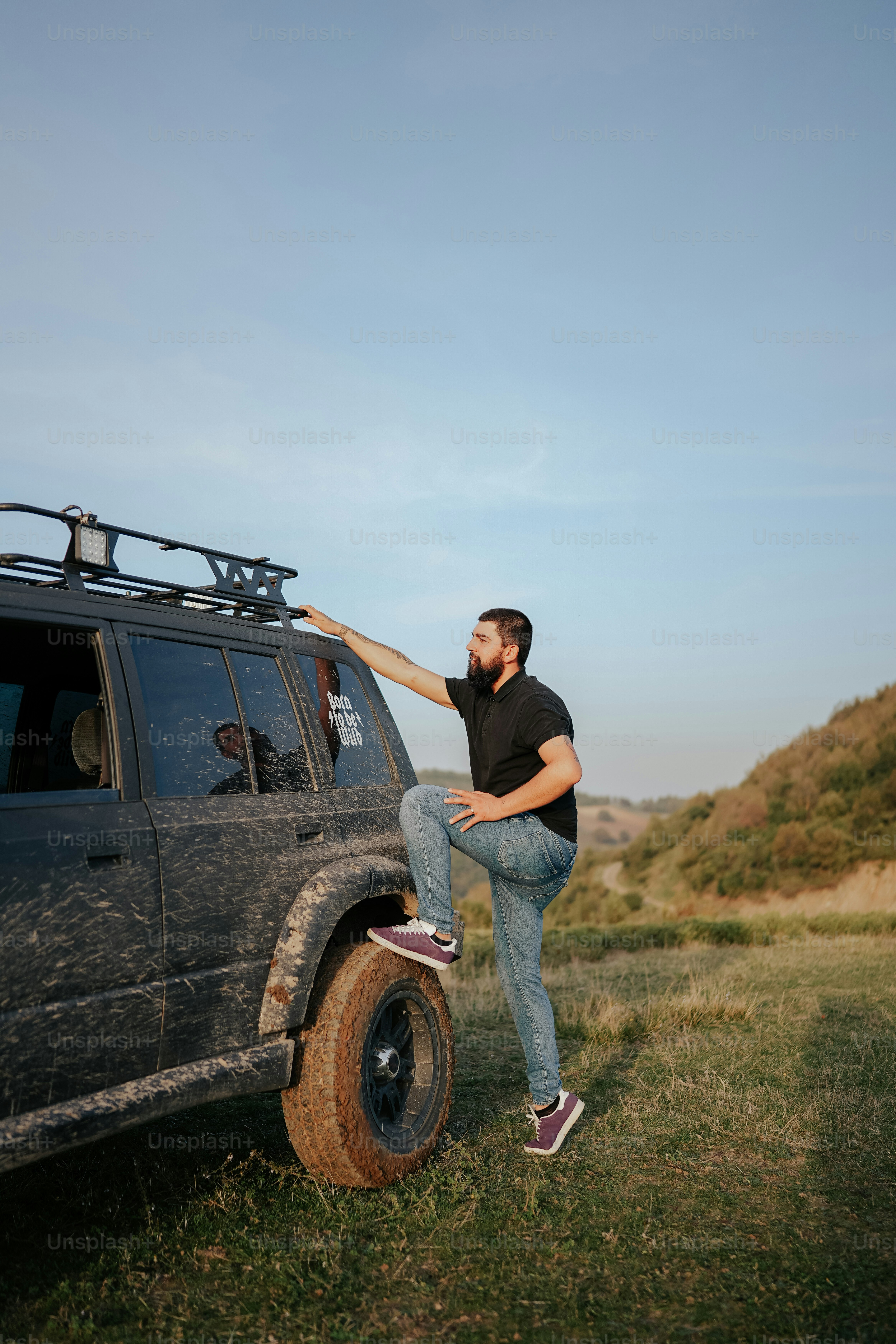 un homme appuyé sur le pneu d’un véhicule
