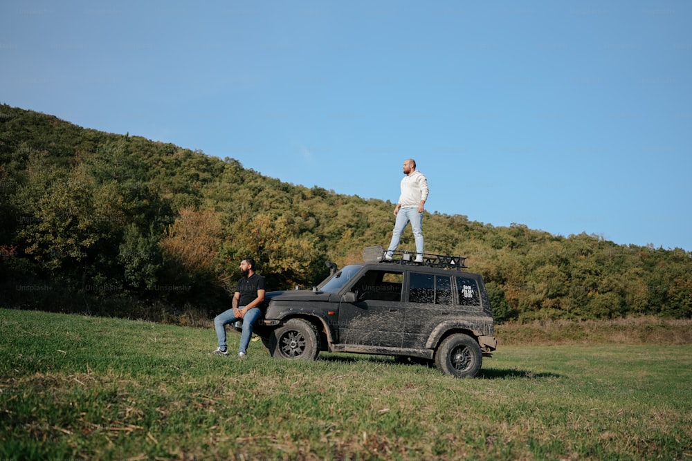 a man standing on top of a jeep