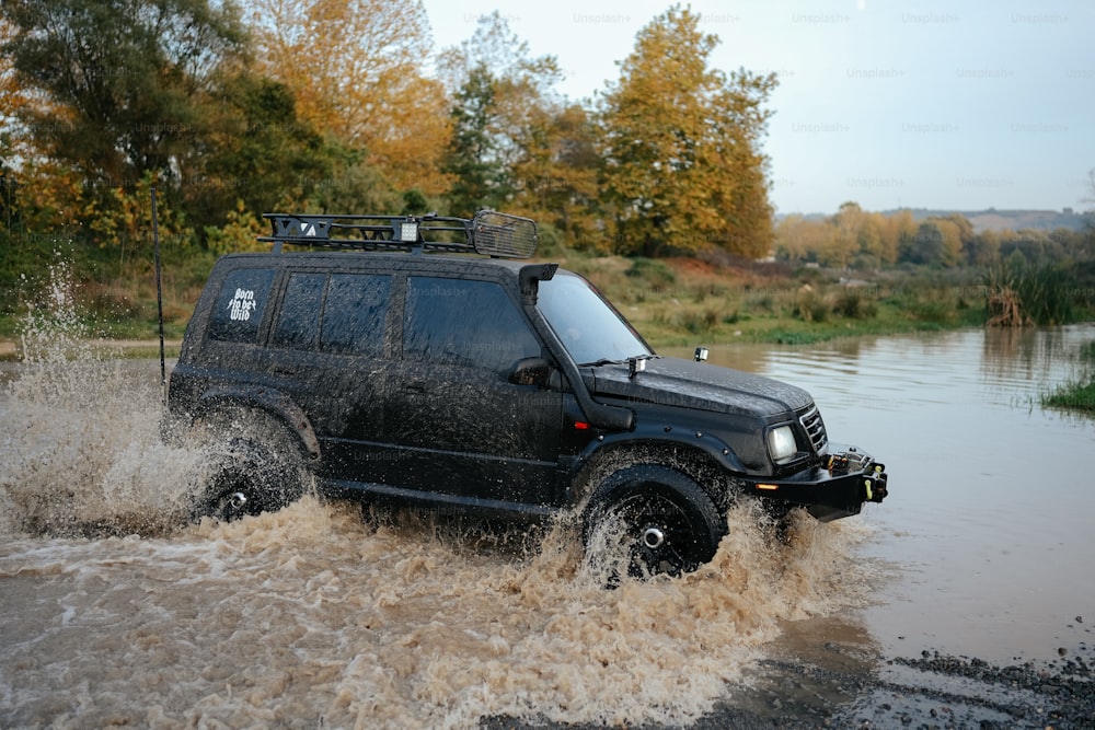 a black jeep driving through a flooded road