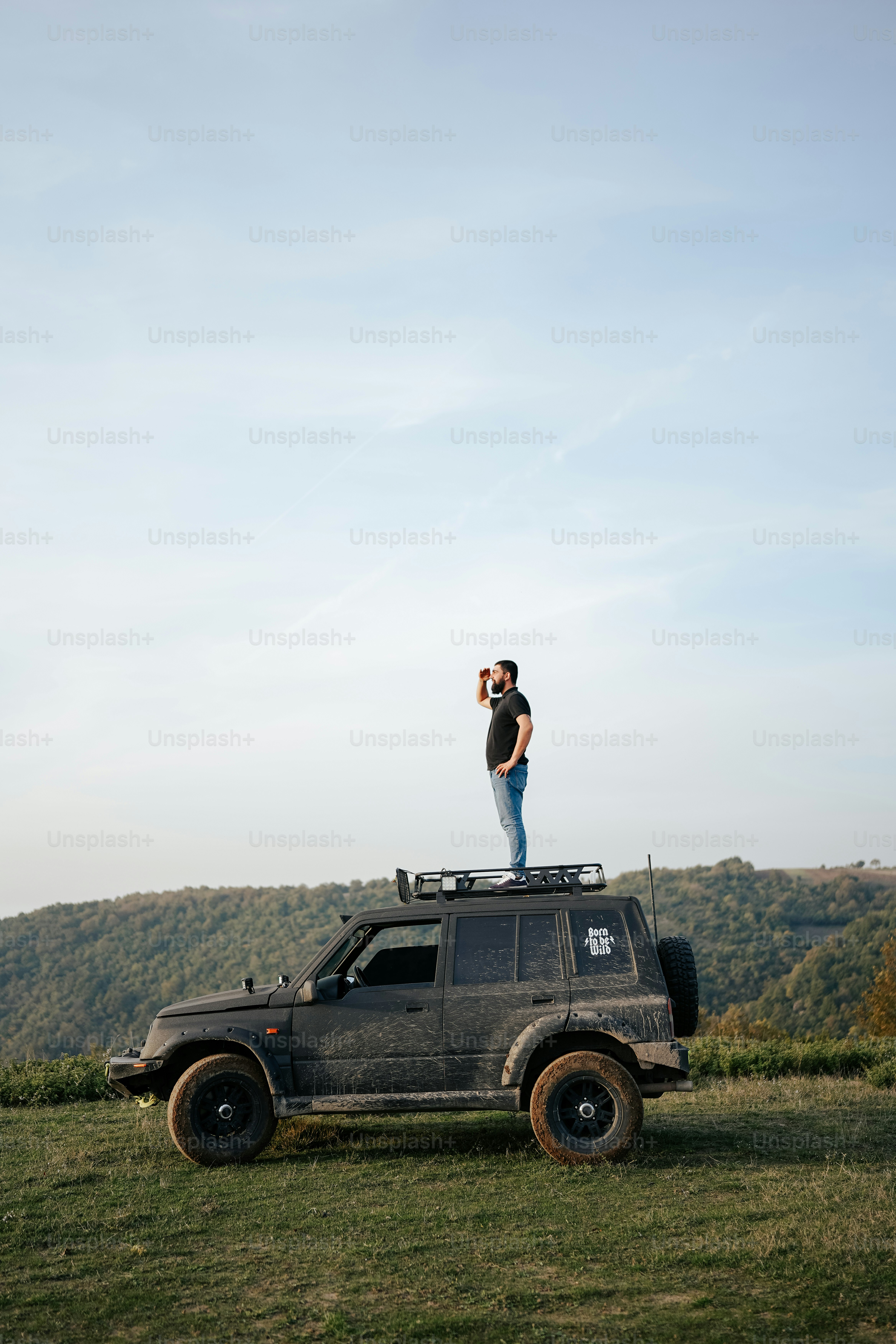 a man standing on top of a jeep