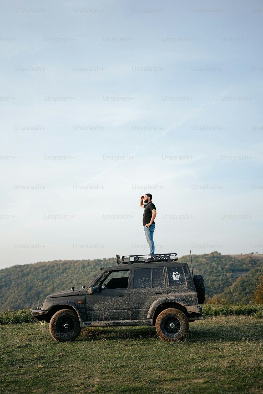 un uomo in piedi sul tetto di una jeep