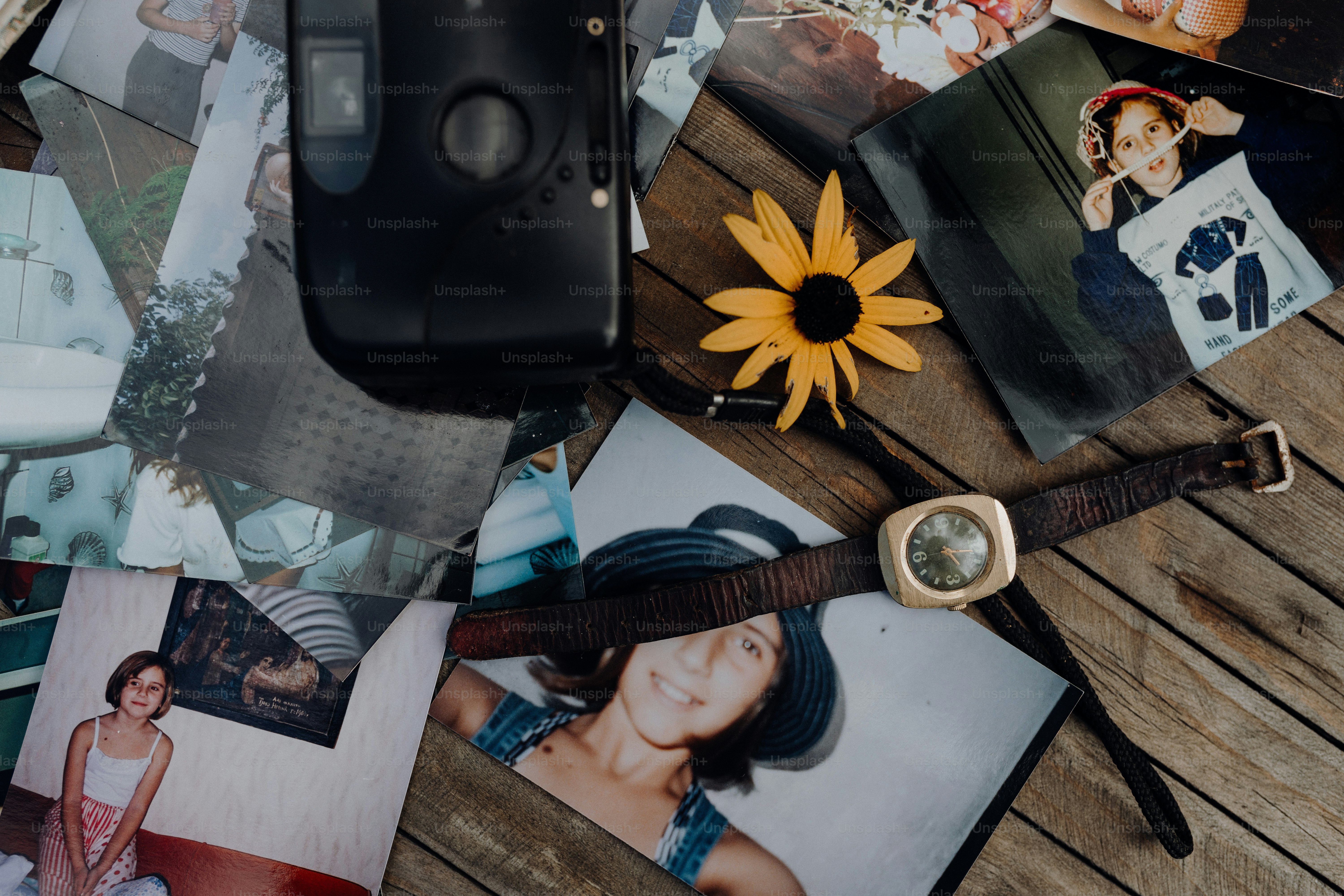 a bunch of pictures and a watch on a table