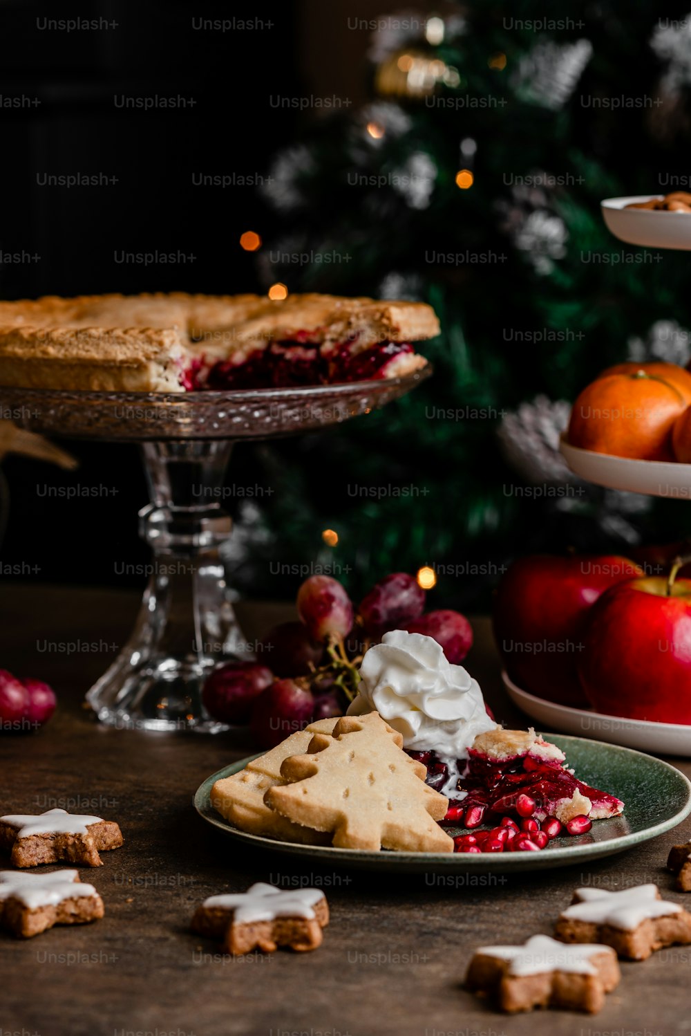 Un tavolo imbandito con piatti di cibo accanto a un albero di Natale