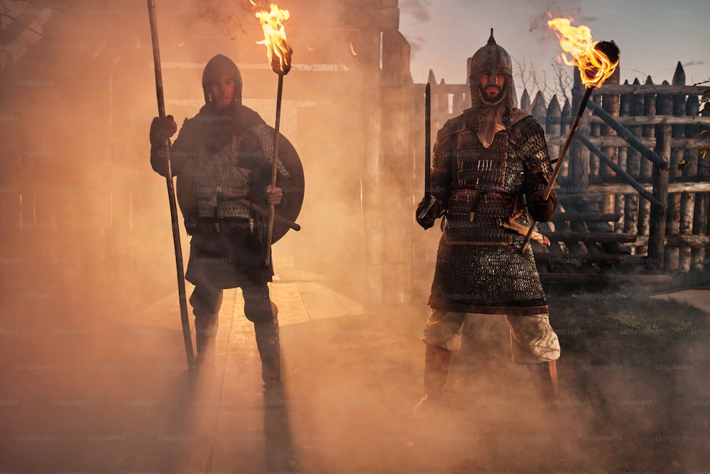 a group of men standing next to each other holding torches