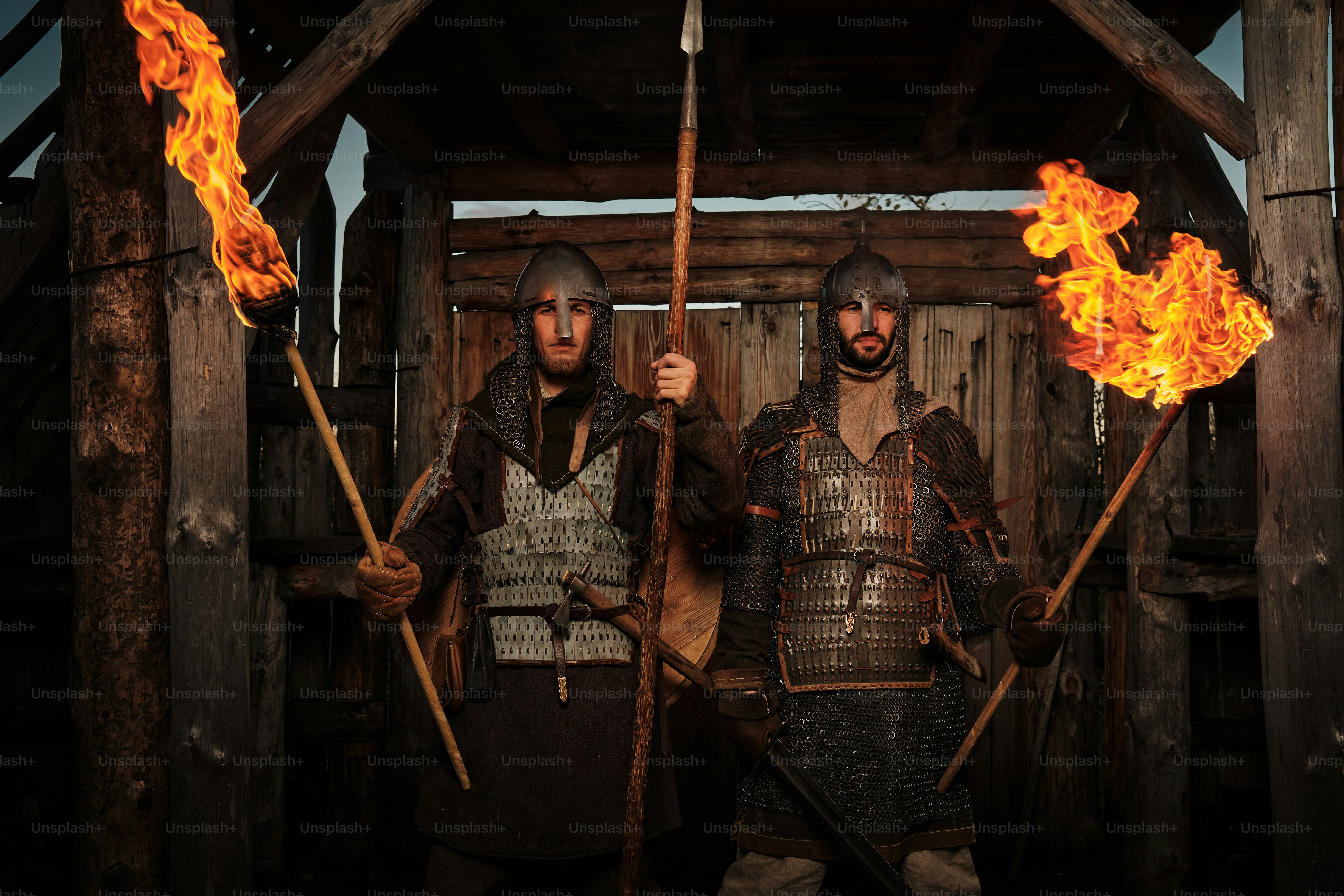 a couple of men standing next to each other holding torches