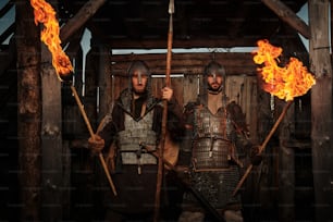 a couple of men standing next to each other holding torches