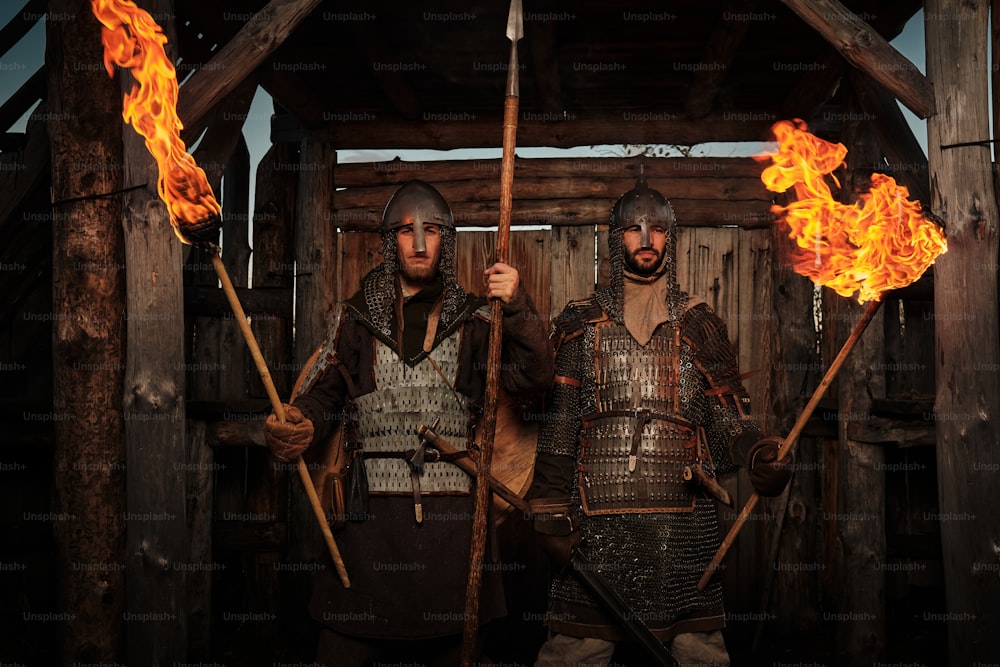 a couple of men standing next to each other holding torches